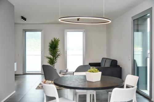a living room with a table and chairs at Stunning Lake View Apartment by Feel Ticino Feel Home in Melide