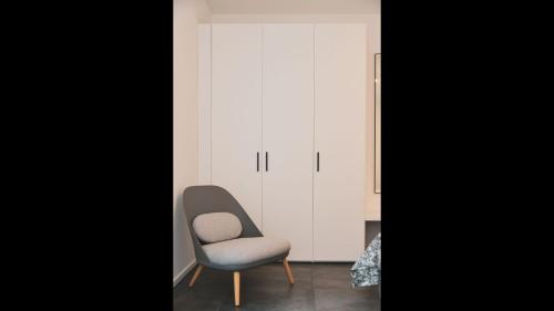 a chair and a cabinet in a room at Stunning Lake View Apartment by Feel Ticino Feel Home in Melide