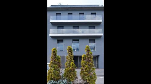 a white building with trees in front of it at Stunning Lake View Apartment by Feel Ticino Feel Home in Melide