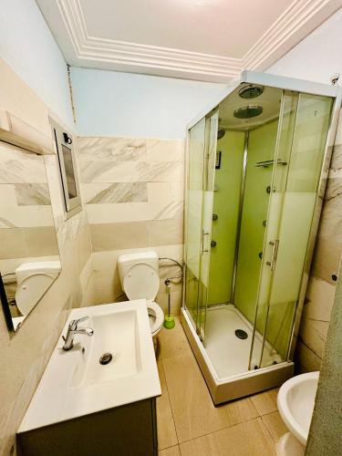 a bathroom with a sink and a shower and a toilet at Villa Amina splendid and elegant in Ouagadougou