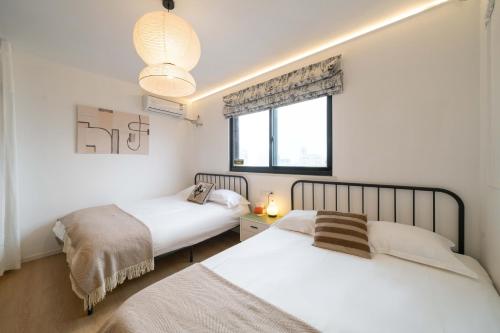 a bedroom with two beds and a window at Shanghai Yi Du B&B - Family Suite 500m to Nanjing West Rd Near People's Square -Credit Cards Accepted in Shanghai
