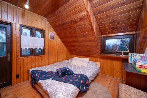 a bedroom with a bed in a wooden cabin at Chata pod lasem in Myślenice
