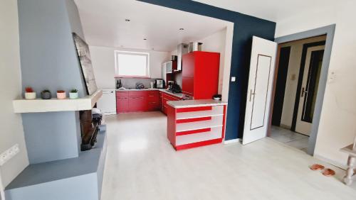 eine Küche mit roten Schränken und einem roten Kühlschrank in der Unterkunft Maison famille et spa in Cornimont