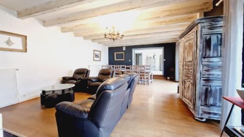 - un salon avec des fauteuils en cuir et une salle à manger dans l'établissement Maison famille et spa, à Cornimont