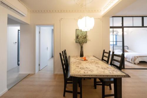a dining room with a table and chairs and a bed at Shanghai Yi Du B&B - Family Suite 500m to Nanjing West Rd Near People's Square -Credit Cards Accepted in Shanghai