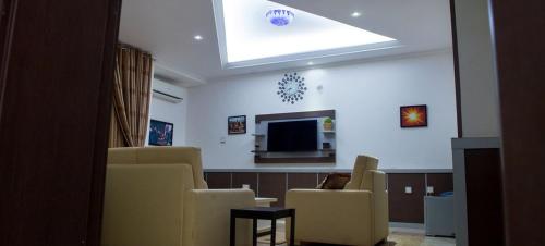 a waiting room with chairs and a flat screen tv at Grand Cubana Hotels-apartment in Jabi