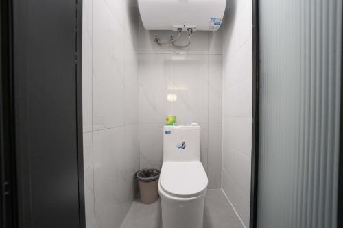 a white bathroom with a toilet and a trash can at Shanghai Yi Du B&B - Family Suite 500m to Nanjing West Rd Near People's Square -Credit Cards Accepted in Shanghai