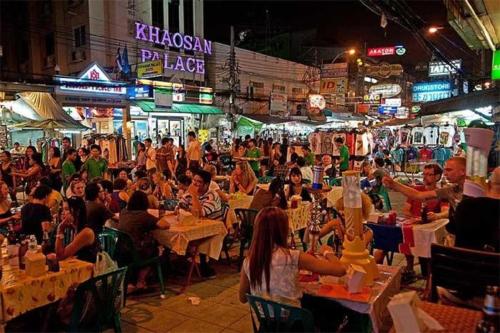 a crowd of people sitting at tables in a market at night at XX GO INN Khaosan ข้าวสาร กรุงเทพมหานคร in Bangkok
