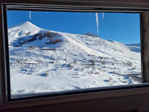 a view of a snow covered mountain from a window at Panorama in Gudauri