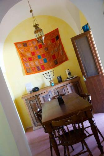 a dining room with a wooden table and a wall at Dammusi Ambra in Pantelleria