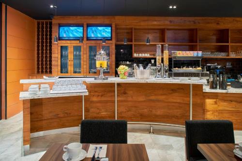 a bar in a restaurant with wooden walls and tables at Courtyard by Marriott Mexico City Toreo in Mexico City