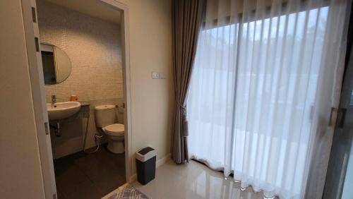 a bathroom with a toilet and a sink and a window at La-ngu Homie in Langu