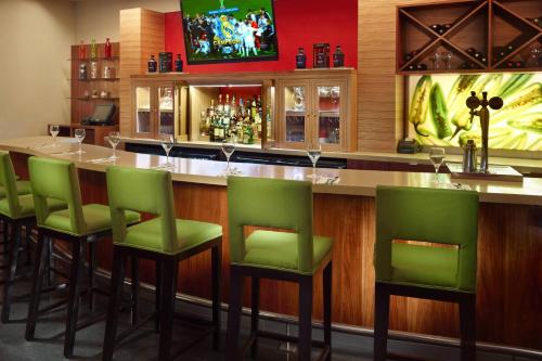 a bar with green bar stools in a restaurant at Courtyard by Marriott Mexico City Airport in Mexico City