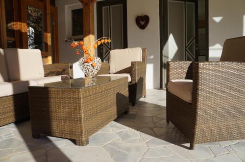 a group of wicker chairs and a table on a porch at Apartment Bad Kleinkirchheim in Bad Kleinkirchheim