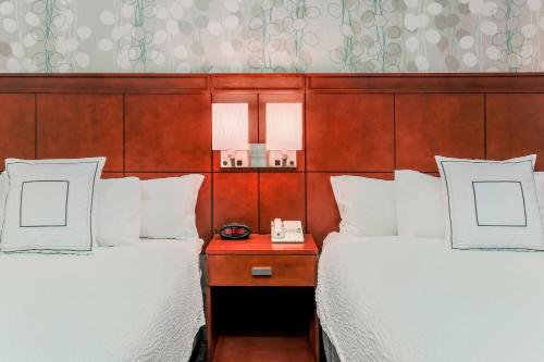 a hotel room with two beds and a telephone at Courtyard by Marriott Orlando Lake Mary North in Lake Mary