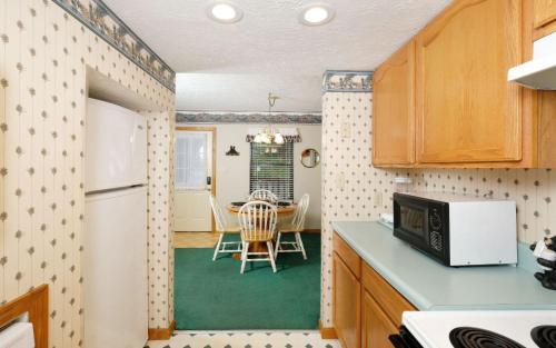 a kitchen with a table and a white refrigerator at Bear Hugs 1126 in Gatlinburg