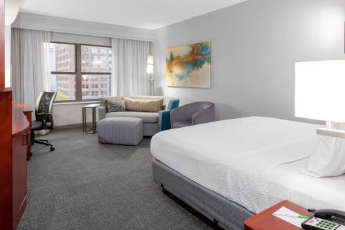 メンフィスにあるCourtyard Memphis Downtownのベッドとソファのあるホテルの部屋