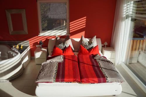 ein rotes Schlafzimmer mit einem Bett mit roten Kissen in der Unterkunft Apartment Bad Kleinkirchheim in Bad Kleinkirchheim