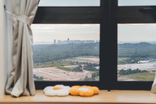 three donuts sitting on a window sill looking out at a city at Wonderland Loft Sunway Grid Kid Friendly by Our Stay in Iskandar Puteri