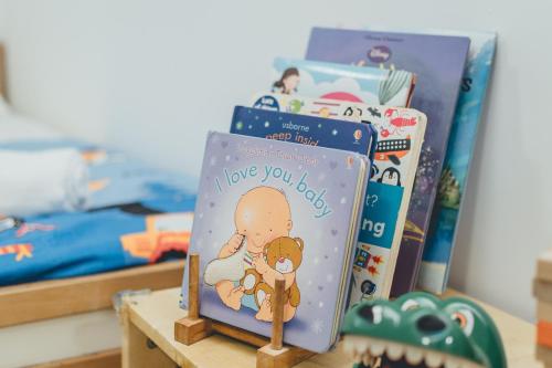 a group of books on a table in a bedroom at Wonderland Loft Sunway Grid Kid Friendly by Our Stay in Iskandar Puteri