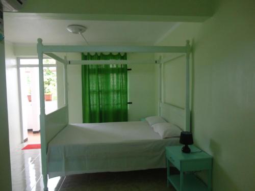 ein Schlafzimmer mit einem Himmelbett und einem Fenster in der Unterkunft Sunshine Villa in Grand Baie