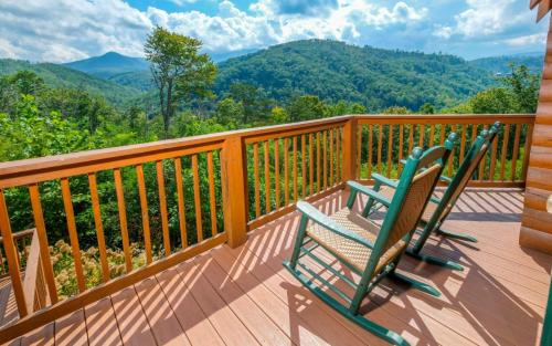 a rocking chair on a deck with a view of mountains at New Fox Lodge in Gatlinburg