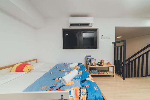 a bedroom with a bed with a blue comforter and a tv at Wonderland Loft Sunway Grid Kid Friendly by Our Stay in Iskandar Puteri