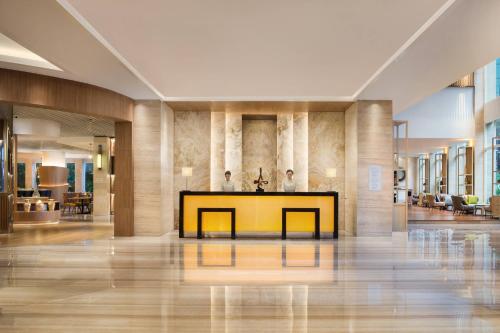 a lobby with a yellow table in the middle at Courtyard by Marriott Bandung Dago in Bandung