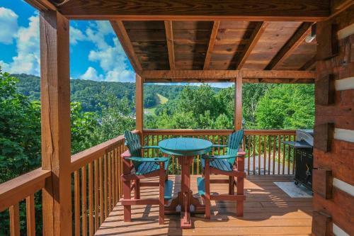 a deck with a table and chairs and a grill at Mountain Splendor 1250 in Gatlinburg