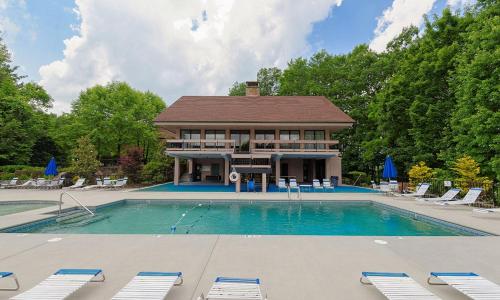 a large swimming pool with chairs and a house at Mountain Splendor 1250 in Gatlinburg