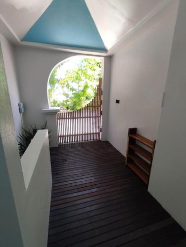 a hallway with a blue ceiling and a window at SWIMS Maldives in Omadhoo