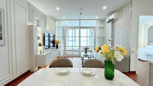 a living room with a table with flowers in a vase at Vinhomes Time City Luxury Apartment in Ha Noi in Hanoi