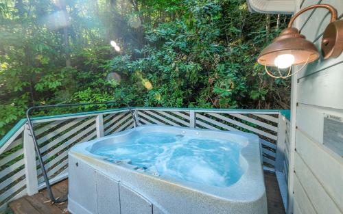 a hot tub on a deck with a lamp and trees at Bonnie and Clyde in Gatlinburg