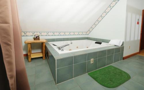 a bath tub in a bathroom with a green tile floor at Bonnie and Clyde in Gatlinburg