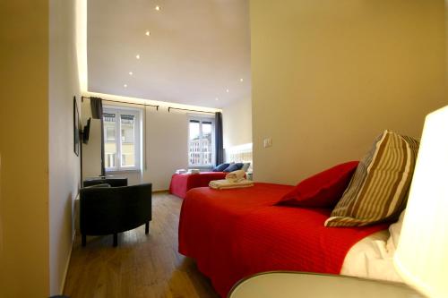 a bedroom with a red bed and a chair at Passenger Vatican Relais in Rome
