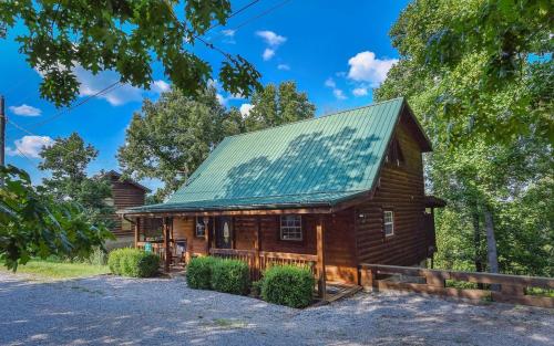 a log cabin with a green roof at Hooked On Love in Sevierville