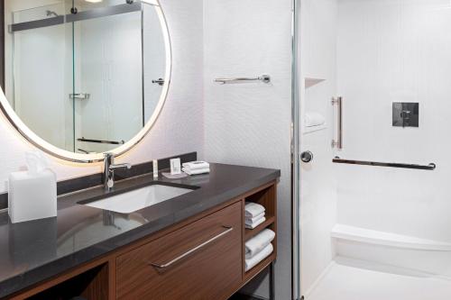 a bathroom with a sink and a mirror at Courtyard by Marriott Atlanta Midtown in Atlanta