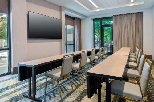 a conference room with a table and chairs and a flat screen tv at Courtyard by Marriott Atlanta Midtown in Atlanta