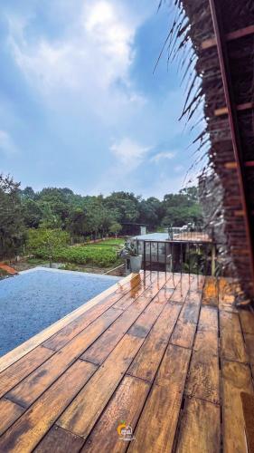 a wooden deck next to a swimming pool at Habarana Tree House Ambasewana Resort in Habarana