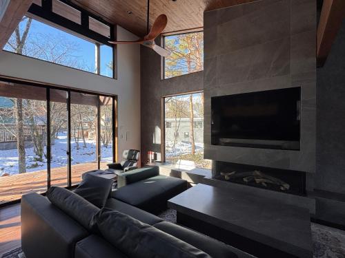 a living room with a couch and a fireplace at Forest Gardens by Hakuba White Fox Company in Hakuba