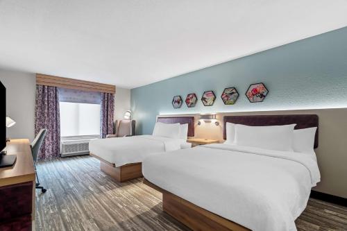 a hotel room with two beds and a television at Hilton Garden Inn Cartersville in Cartersville