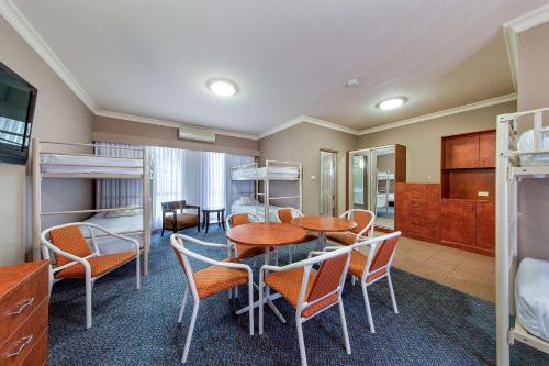 a room with bunk beds and a table and chairs at Quality Inn Penrith Sydney in Penrith