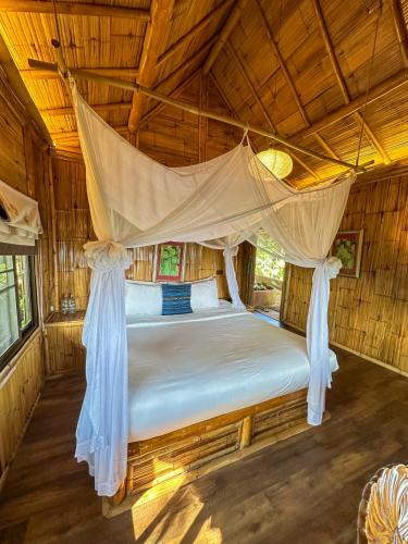 a bed in a room with a mosquito net at Phu Chaisai Chiang Rai Mountain Resort in Mae Salong Nai