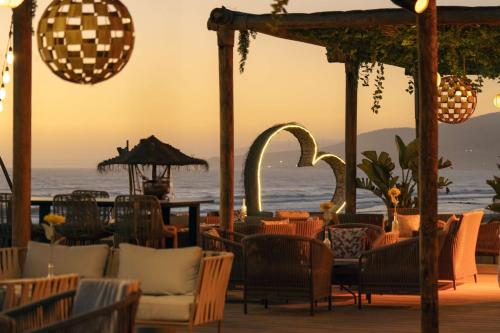a restaurant with chairs and tables and the ocean at Hilton Taghazout Bay Beach Resort & Spa in Taghazout