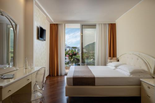 a hotel room with a bed and a balcony at Hotel Savoy Palace - Tonelli Hotels in Riva del Garda