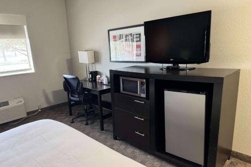 a hotel room with a television and a desk with a bed at Comfort Inn Huntington near University area in Huntington