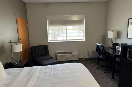 a hotel room with a bed and a desk and a chair at Comfort Inn Huntington near University area in Huntington