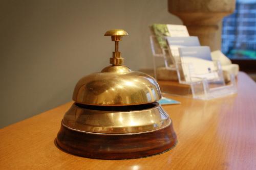 a bell sitting on top of a wooden table at Novitel Hotel Kirchheim - München Messe in Kirchheim