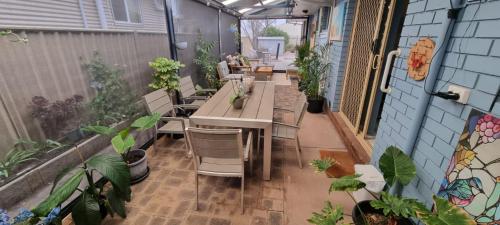 an outdoor patio with tables and chairs and plants at Ocean Street Delight in Esperance