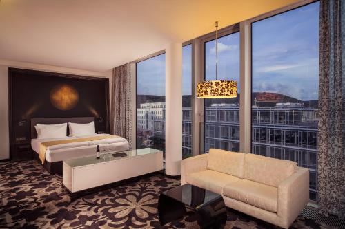 a hotel room with a bed and a large window at Kameha Grand Bonn in Bonn
